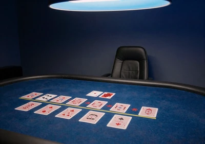 Klassischer Blackjack-Tisch mit blauem Casea-Tuch und einem Kartendeck
