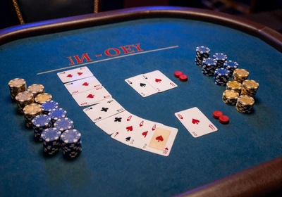 Baccarat-Tisch mit aufgef&auml;cherten Karten und Gold-Chips im Casea Live Casino